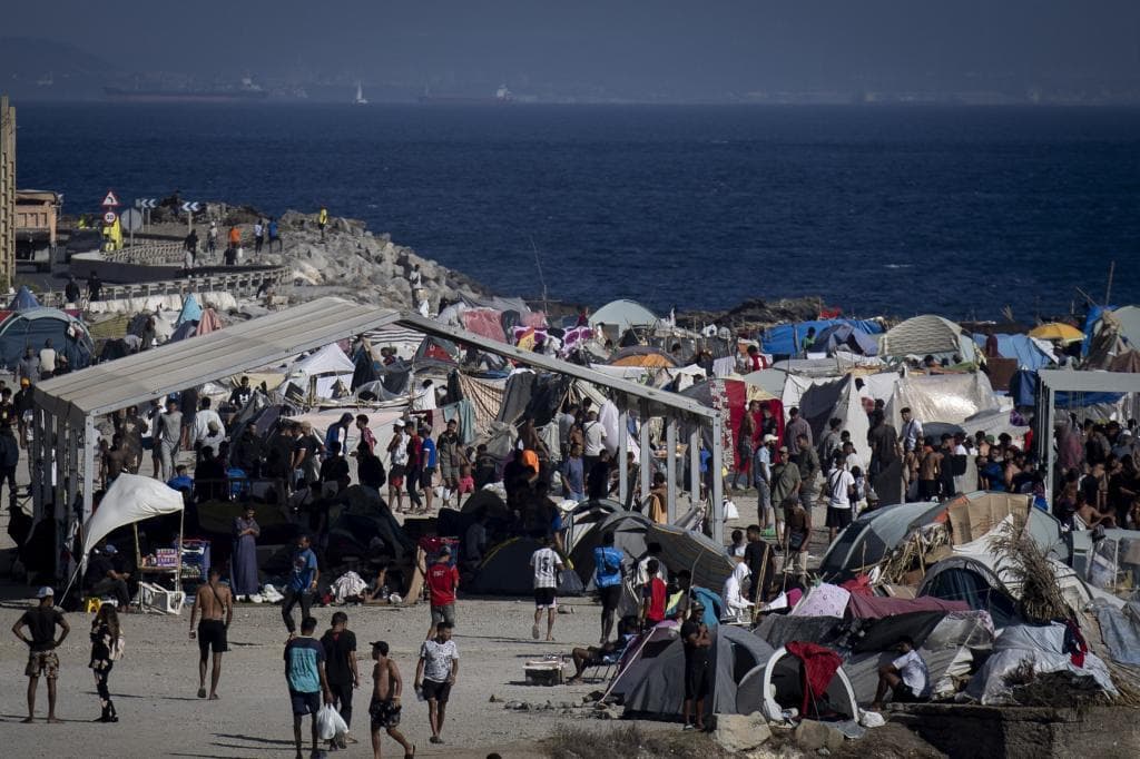 Migrantes cruzando la frontera en Ceuta en una operación de control policial