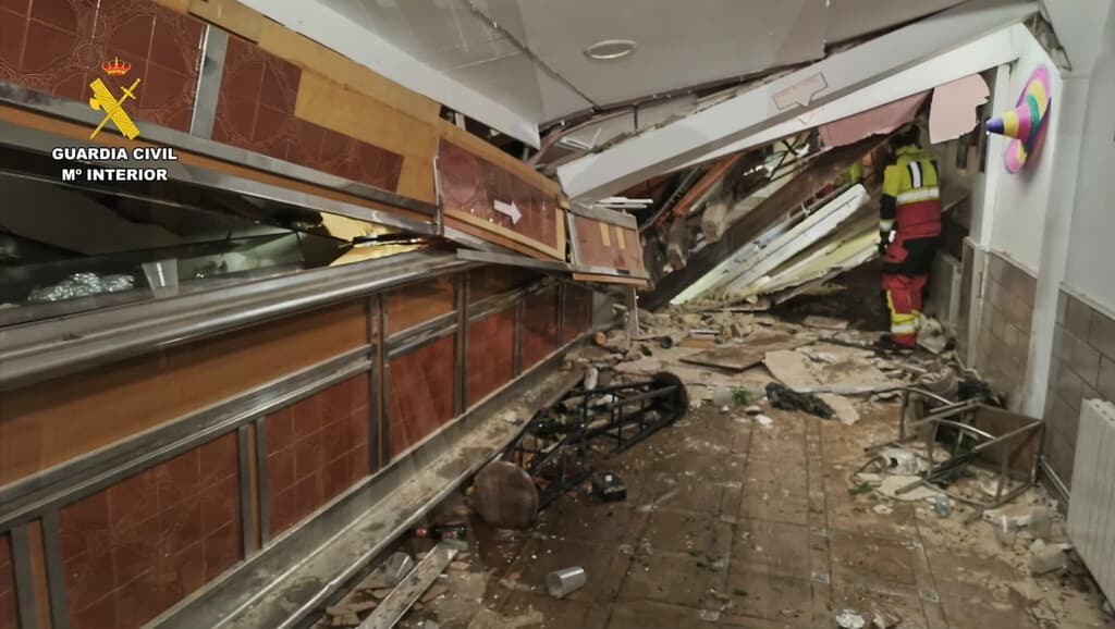 Rescatistas en el interior del bar hundido en La Rioja, con restos de estructura y cavidad oculta visible.