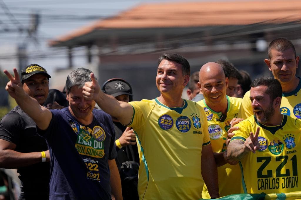 Flávio Bolsonaro en un acto político con banderas brasileñas de fondo
