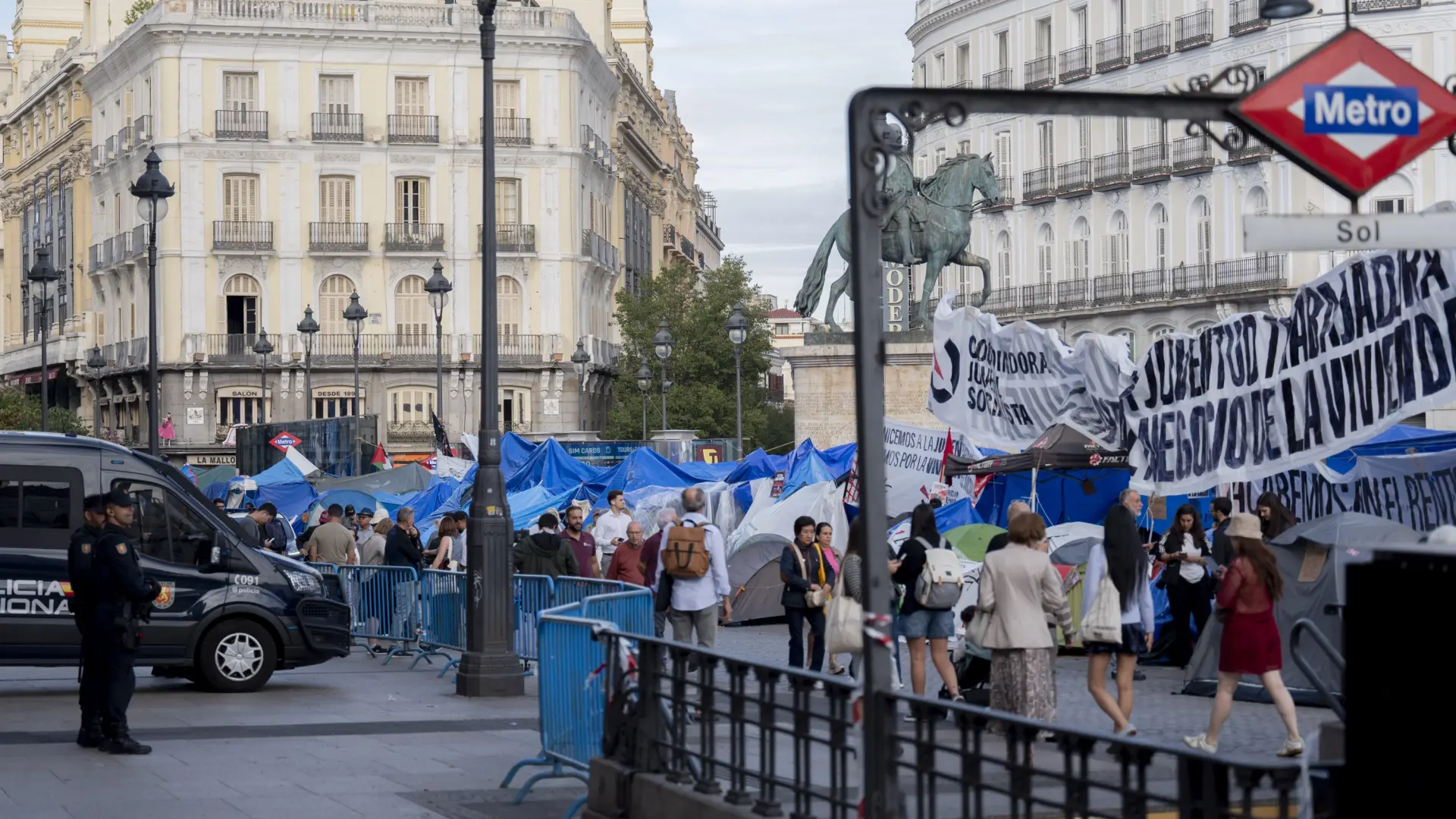 Protestantes en la acampada de Puerta del Sol con pancartas y ambiente de movilización social en Madrid.
